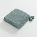 Folded Aqua Knitted Throw Blanket on White Background Showing Tassel