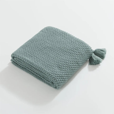 Folded Aqua Knitted Throw Blanket on White Background Showing Tassel