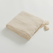 Folded Beige Knitted Throw Blanket Showing Tassel Detail