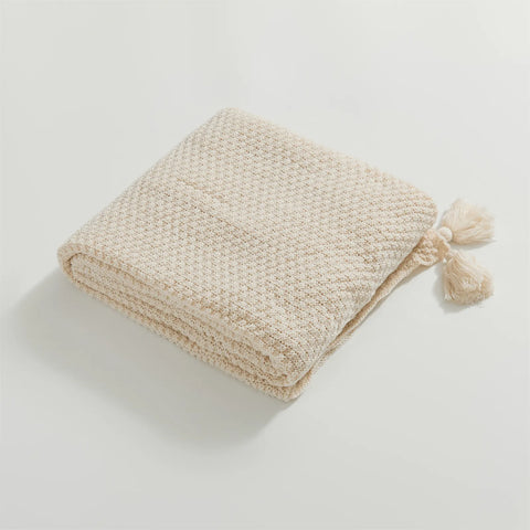 Folded Beige Knitted Throw Blanket Showing Tassel Detail