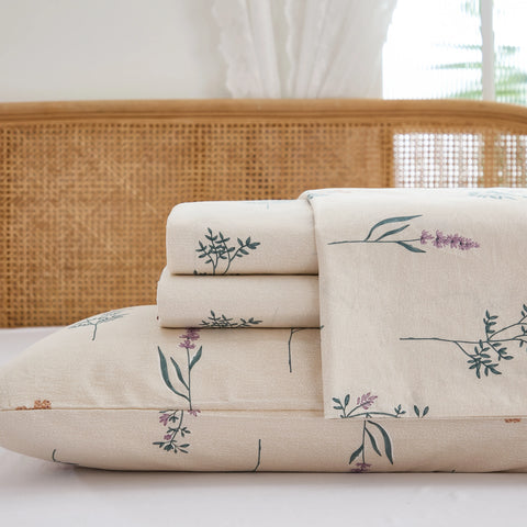 Close up stack of folded cotton wildflower fitted sheet and pillowcases studio shot
