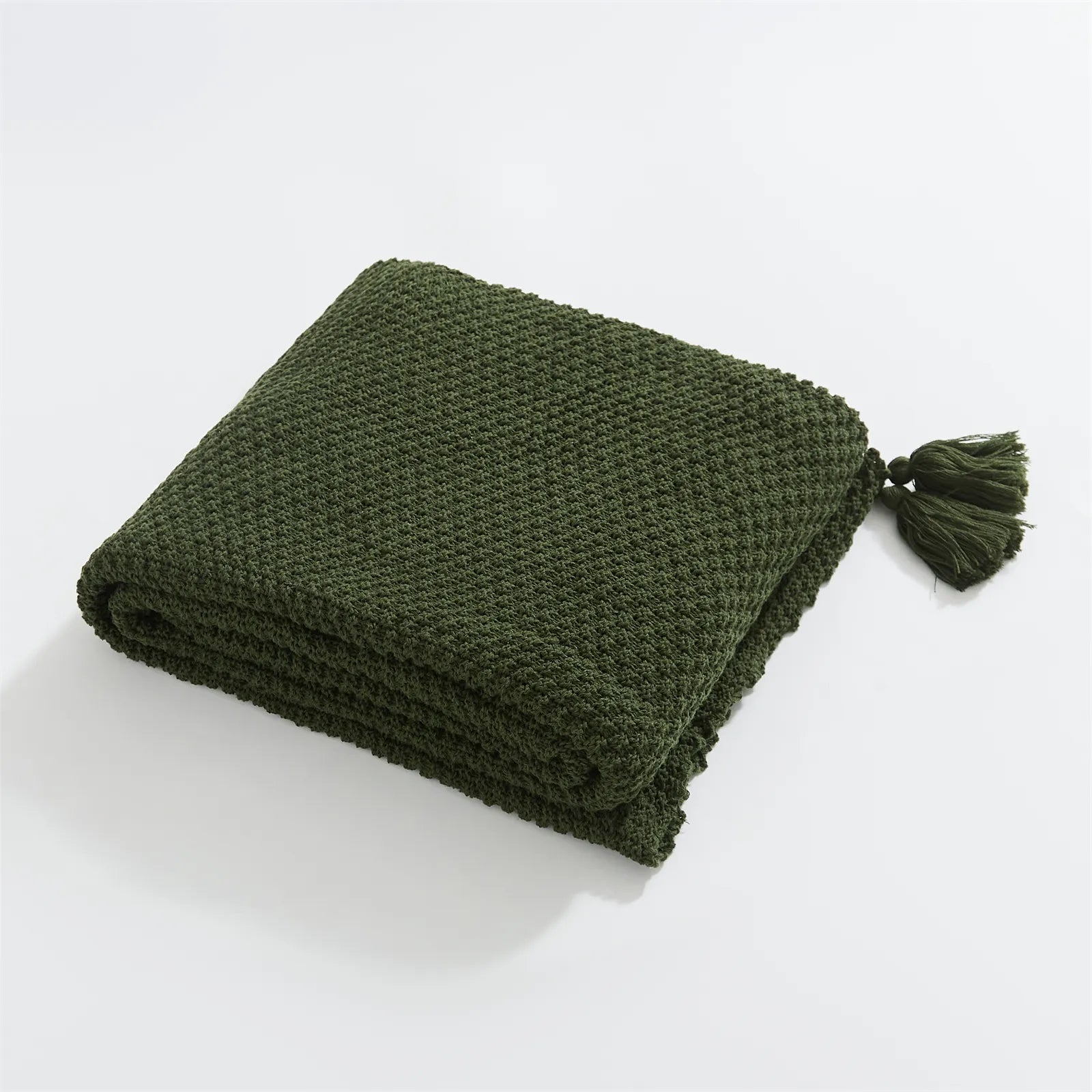 Folded Forest Green Knitted Throw Blanket Showing Tassel on White Background