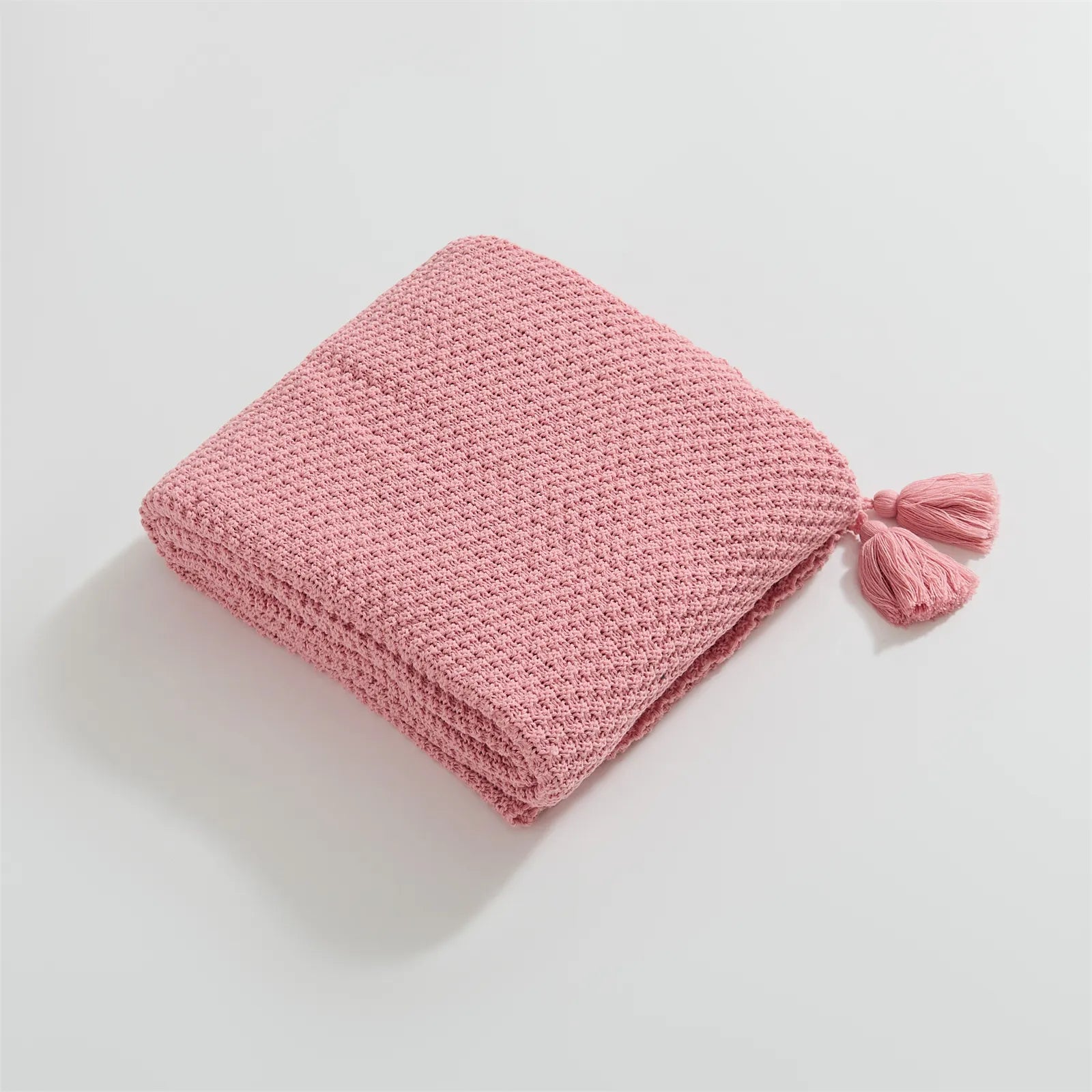 Folded Pink Knitted Throw Blanket Showing Tassel Detail