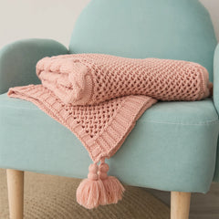 Folded Rose Pink Throw Blanket Neatly Placed on Teal Accent Chair