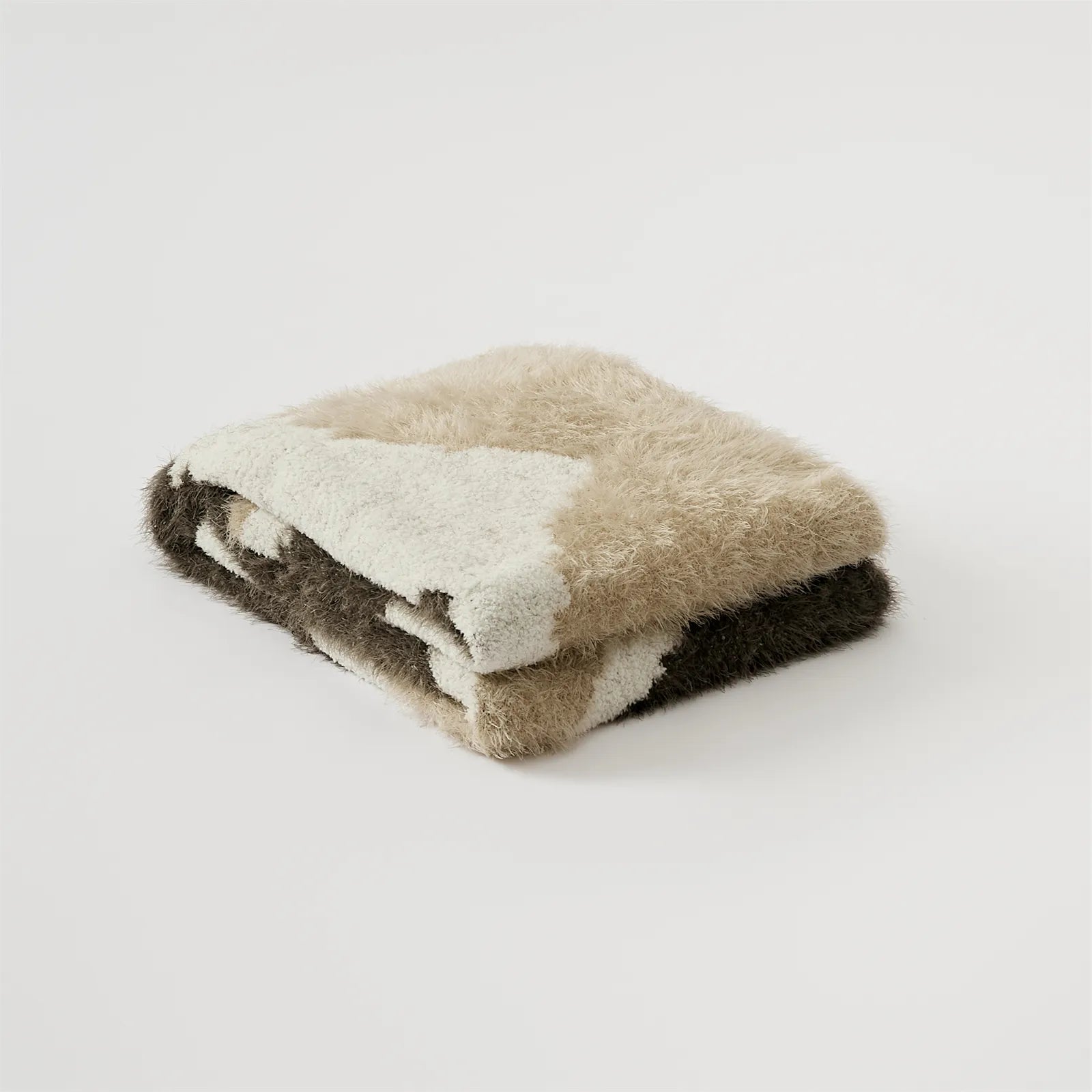 Neatly folded warm taupe mocha and cream abstract fuzzy knit throw blanket studio shot