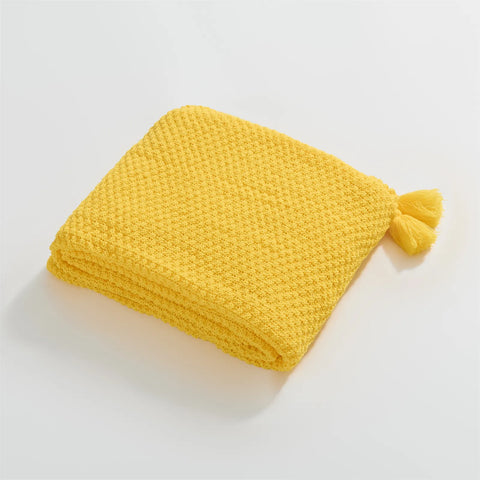 Folded Bright Yellow Knitted Throw Blanket Showing Tassel Detail