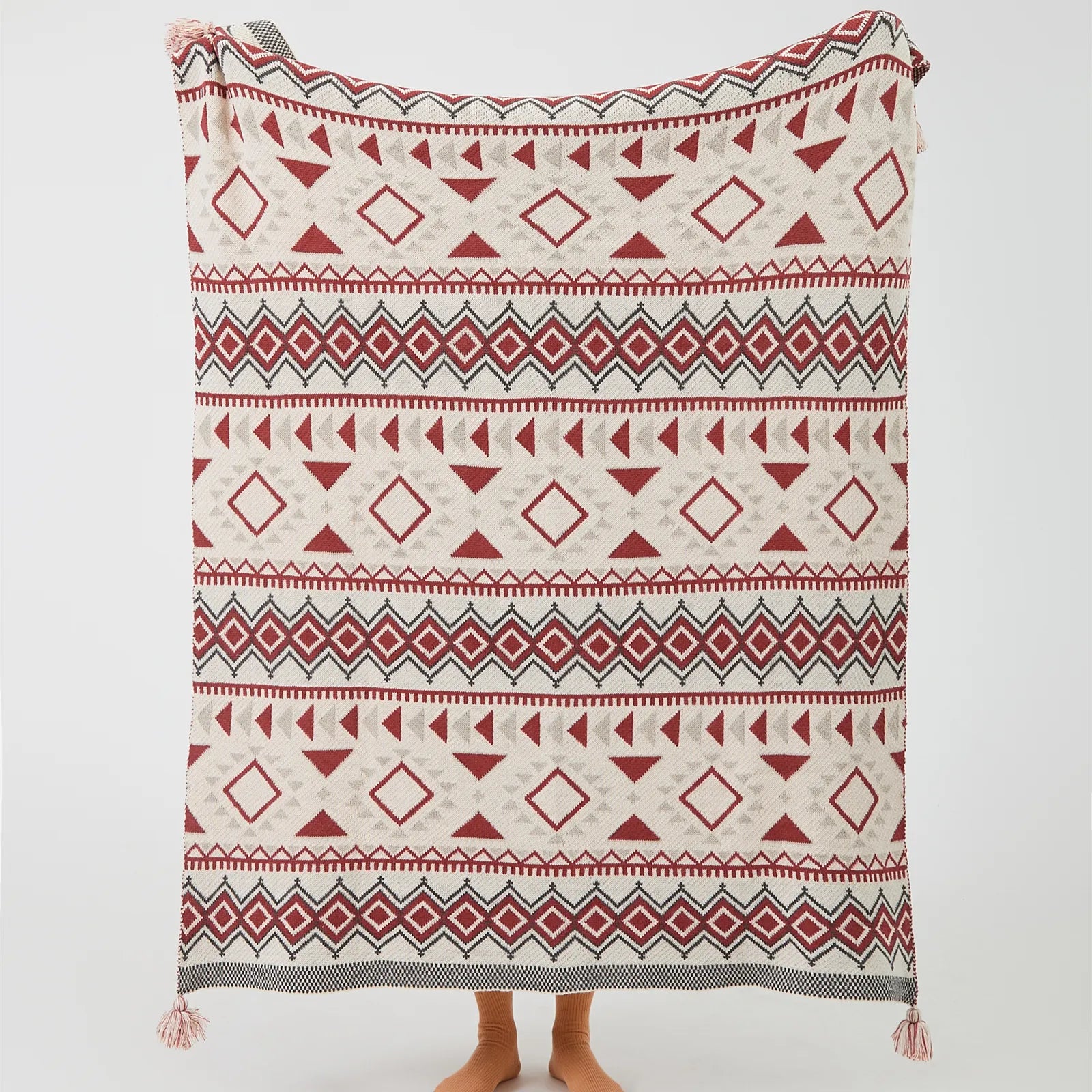 Full size boho vintage geometric knit throw blanket with tassels in rust red and cream studio shot