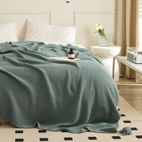 Full View of Aqua Knitted Throw Blanket Showing Tassel by Bedside