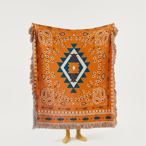Full view of the orange bohemian jacquard cotton throw, showing the central diamond and arrow pattern.