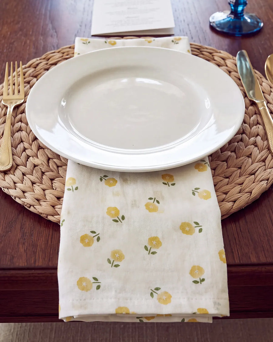 golden ditsy floral cloth napkin under plate
