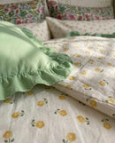 golden ditsy floral duvet cover and sage green ruffle sham detail