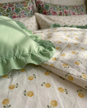 golden ditsy floral duvet cover and sage green ruffle sham detail