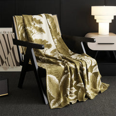 A beautiful green Forest-Inspired blanket is folded on the chair, adding a decorative and comfortable layer.