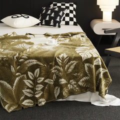 A detailed view of the green forest landscape blanket, showing the intricate woven pattern and soft texture.