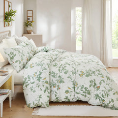 Side view of the green leaf duvet cover set styled on a bed with pillows.