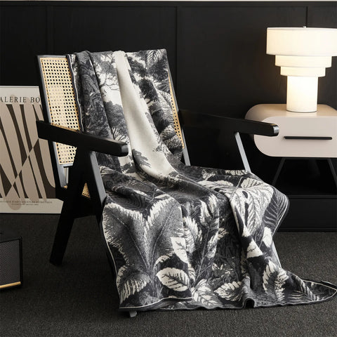 A beautiful grey Forest-Inspired blanket is folded on the chair, adding a decorative and comfortable layer.