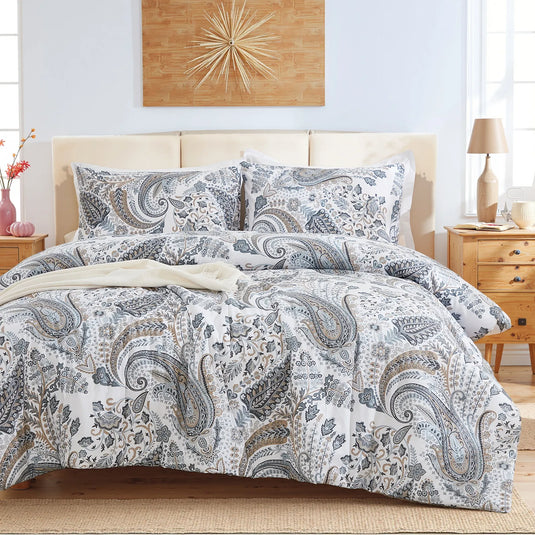 Full view of the grey paisley comforter set styled on a bed in a bright bedroom