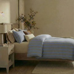 Side view of grey blue striped duvet and pillows
