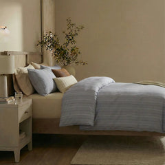 Side view of grey blue striped duvet and pillows