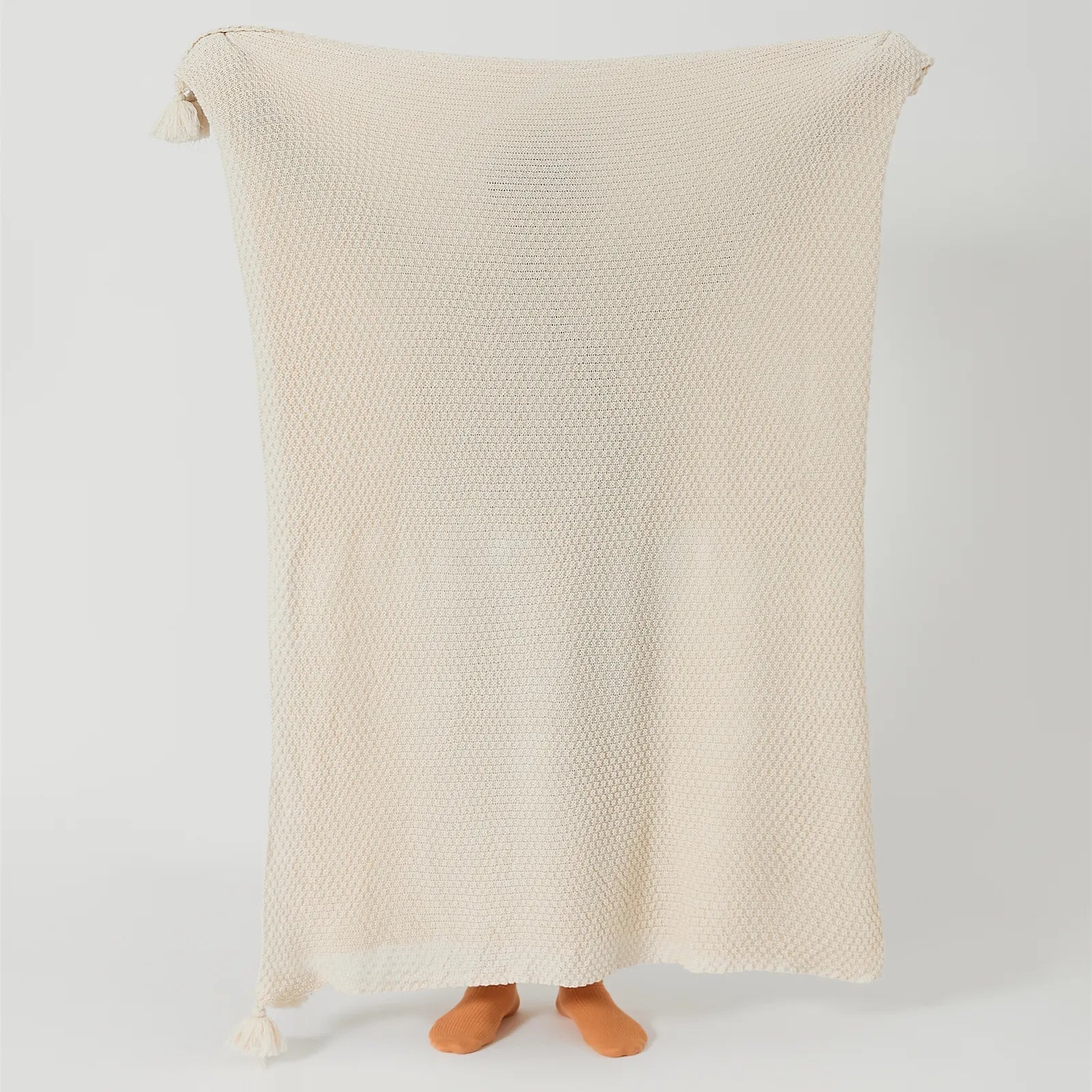 Person Holding Up Beige Knitted Throw Blanket with Tassels Full View