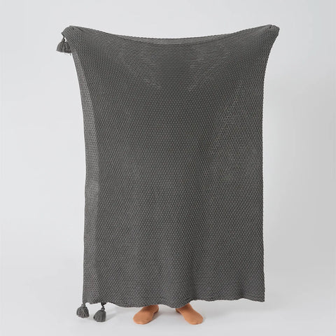 Person Holding Up Grey Knitted Throw Blanket with Tassels Full View