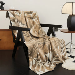 A cozy modern mountainscape knit blanket draped over a chair, adding a serene, natural accent.