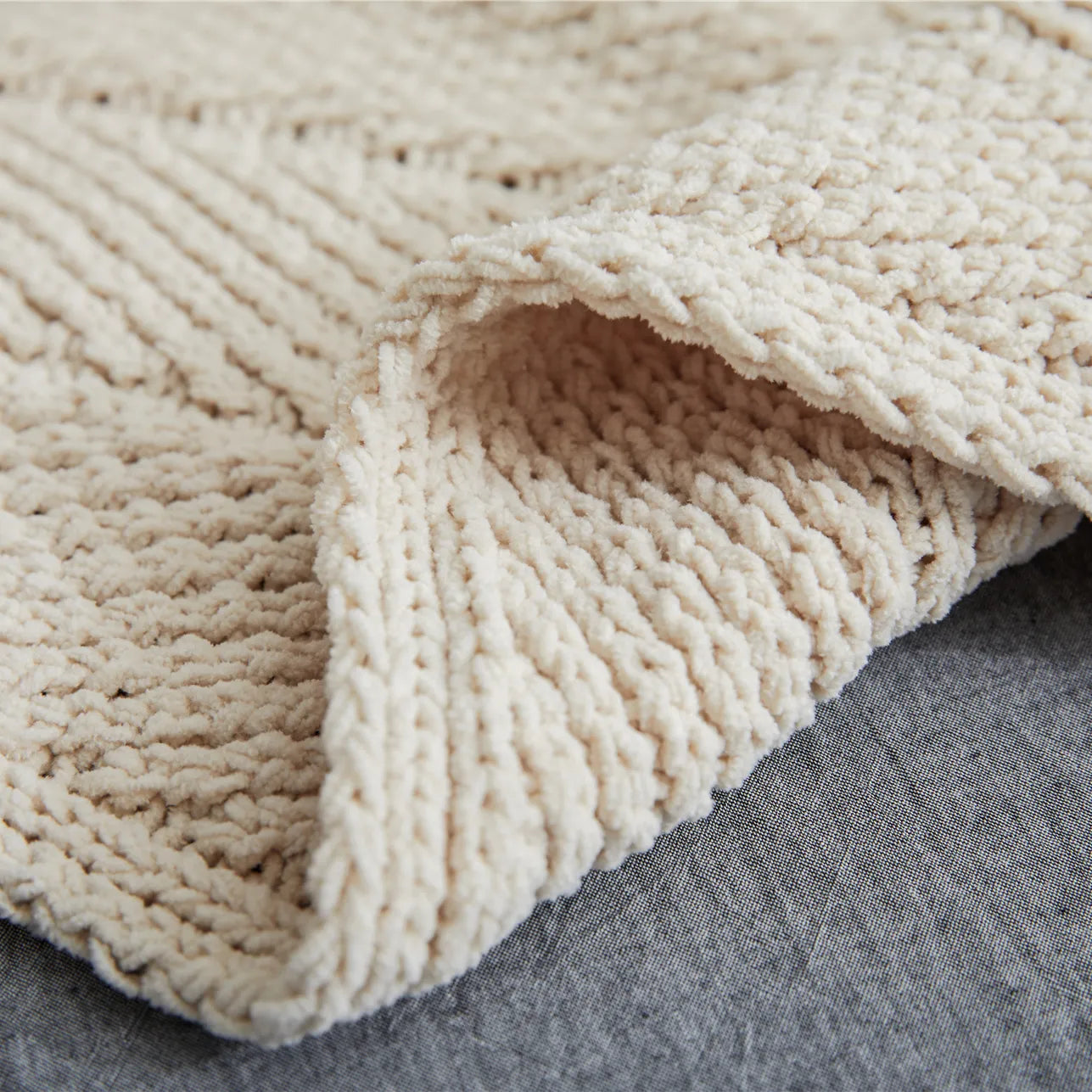 Close up detail of light beige chunky knit fabric texture and soft weave
