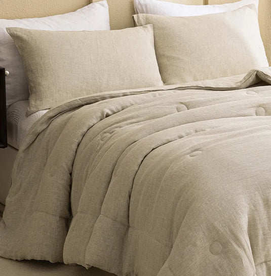 Pair of natural french linen pillowcases styled on a bed with a comforter