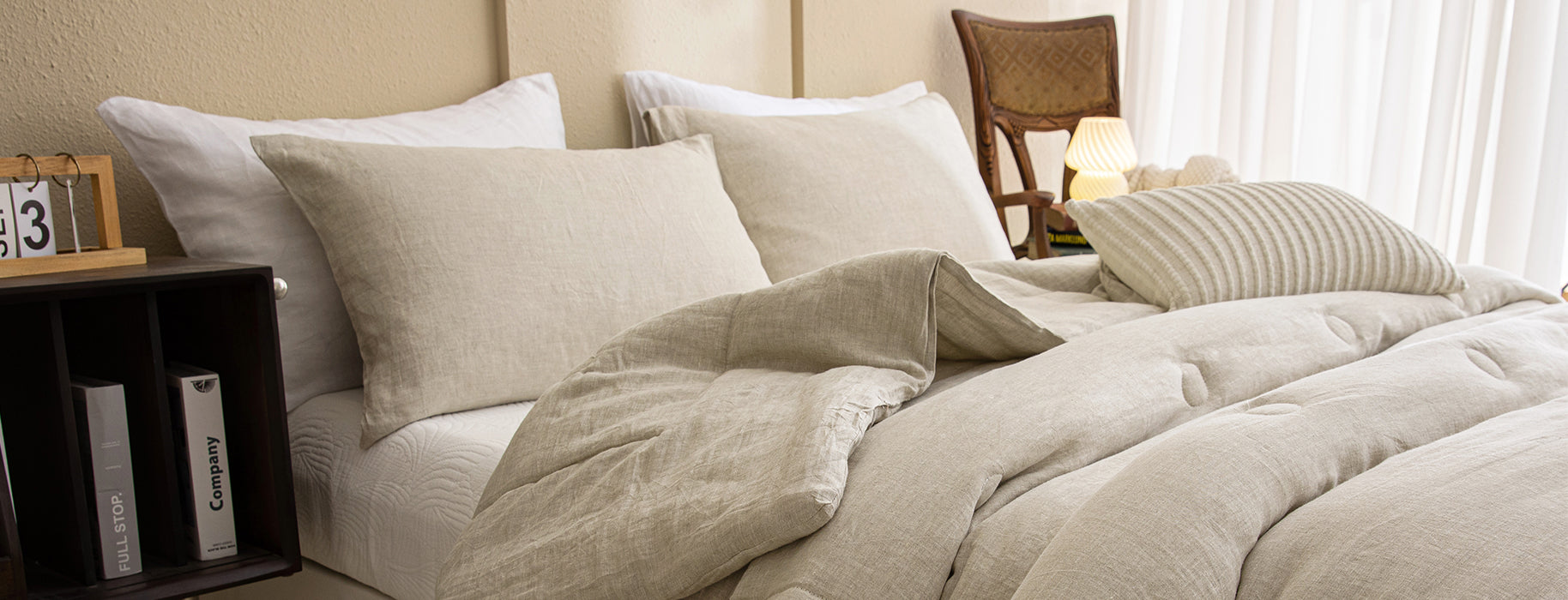 Natural beige linen bedding set, including duvet cover and pillow shams, with a relaxed, stonewashed texture.
