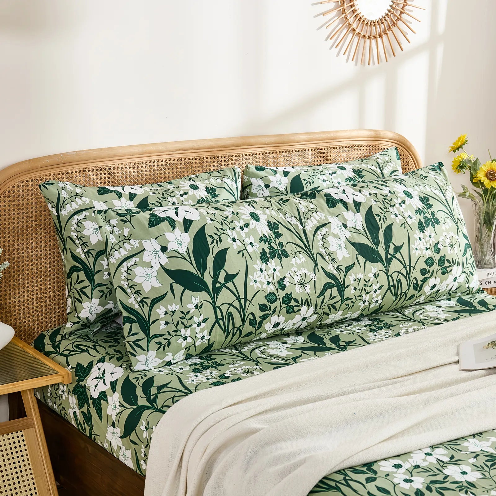 A long cotton body pillow placed horizontally with two standard pillows behind it, both featuring the olive green floral print.