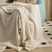 Person Using Beige Knitted Throw Blanket on Teal Armchair