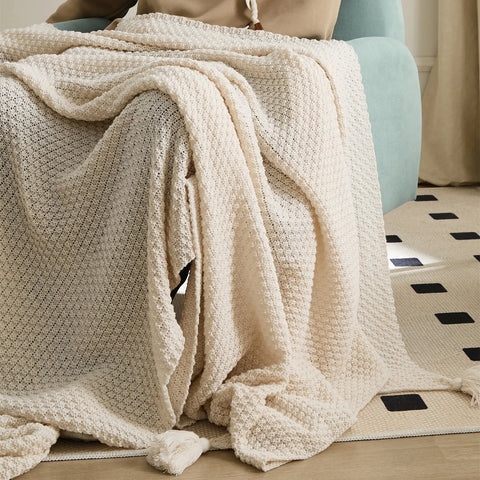 Person Using Beige Knitted Throw Blanket on Teal Armchair