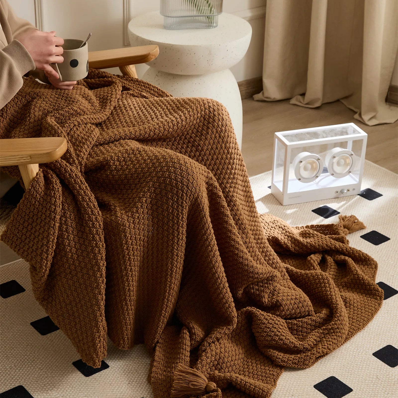 Person Using Brown Knitted Throw Blanket on Wood Chair