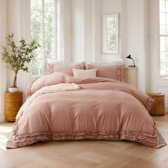 Pink cotton double ruffle duvet cover on a bed with two nightstands holding a lamp and books.
