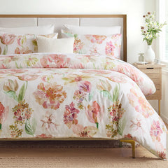 Pink floral comforter set styled in a bedroom with natural light