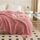 Pink Knitted Throw Blanket with Tassels Draped on Bed