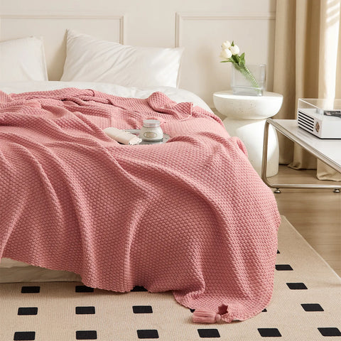 Pink Knitted Throw Blanket with Tassels Draped on Bed