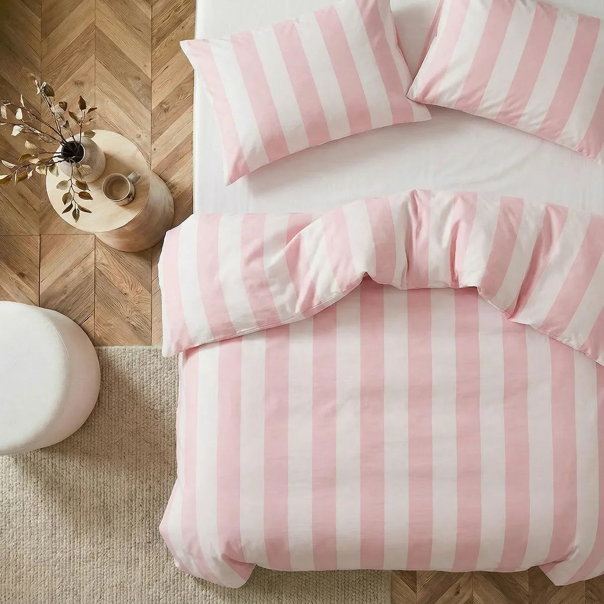 Angled shot of pink and white striped duvet cover on bed