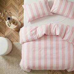 Angled shot of pink and white striped duvet cover on bed
