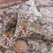 overhead flat lay shot of the moody rose and amber floral print on pillows and duvet set