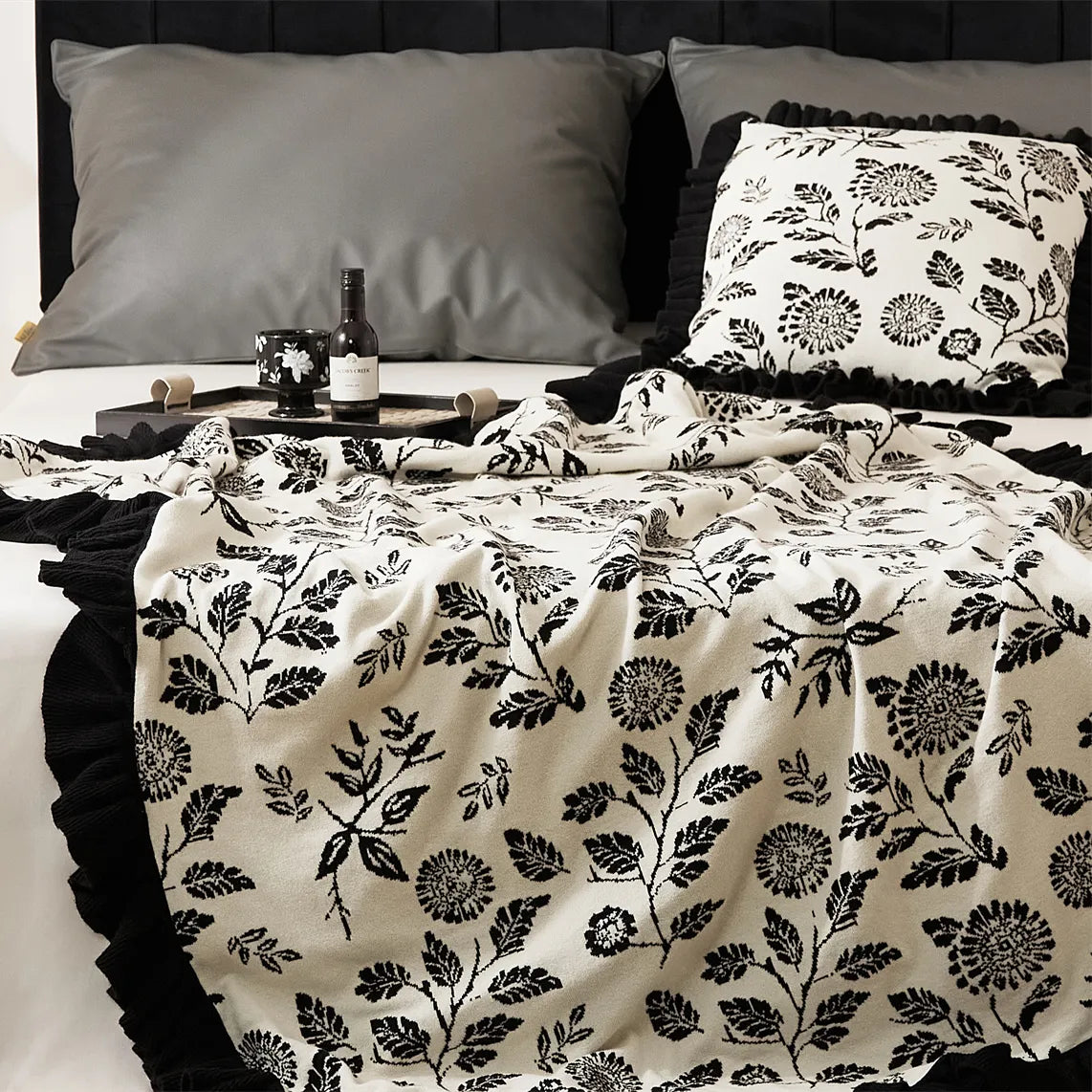 A detailed shot of the microfiber blanket, showcasing the intricate black leaf pattern and plush, soft fabric texture.