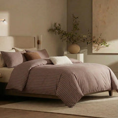 Angled shot of rust red striped duvet cover on bed