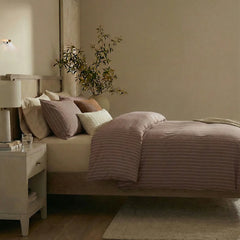 Side view of rust red striped duvet and pillows