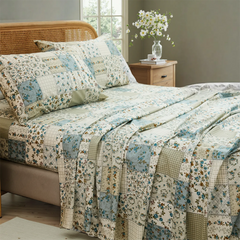 Rustic cotton patchwork floral sheet set on bed with natural light from window