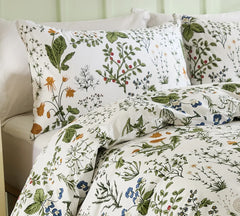 A close-up of a sage green floral pillow showing the pattern