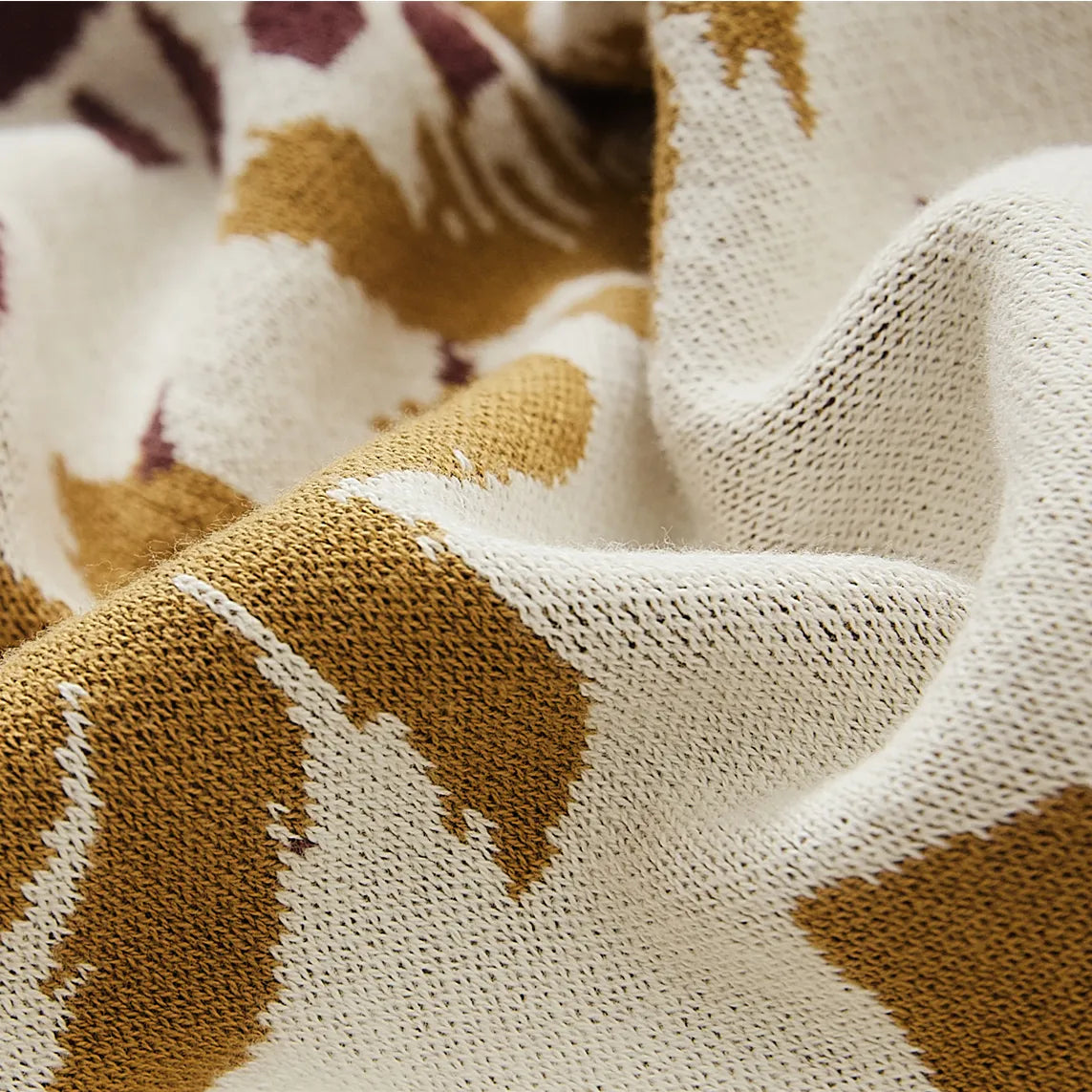 A detailed close-up of the sand yellow bohemian blanket, showing its soft texture, intricate pattern, and tassels.