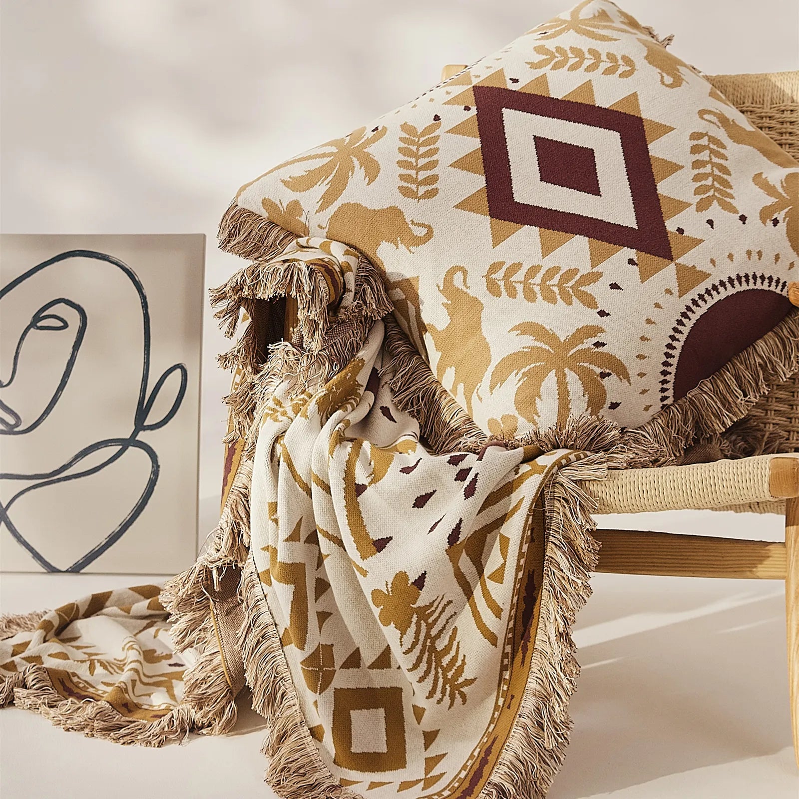 A sand yellow bohemian cotton blanket with tassels, draped stylishly over a light-colored armchair.