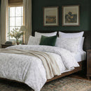 minimalist grey and white botanical bedding set in a bright airy room with rustic wooden bed