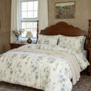 profile view of the serene garden bloom bedding set styled with a cream throw in a cozy room