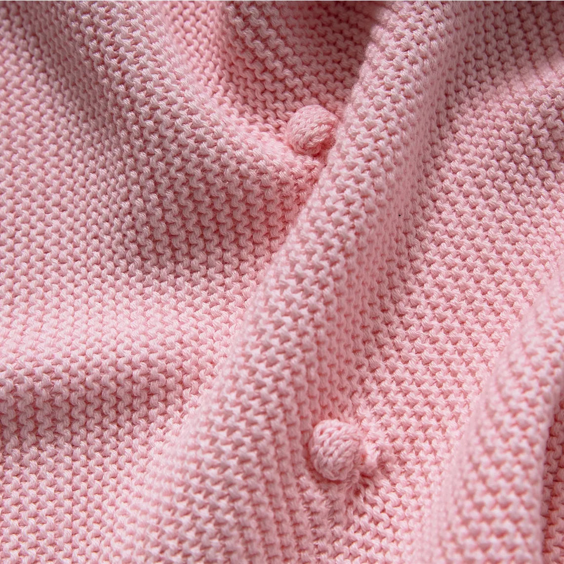 Close up detail of the soft pink cotton knit fabric showing the bobble/popcorn stitch